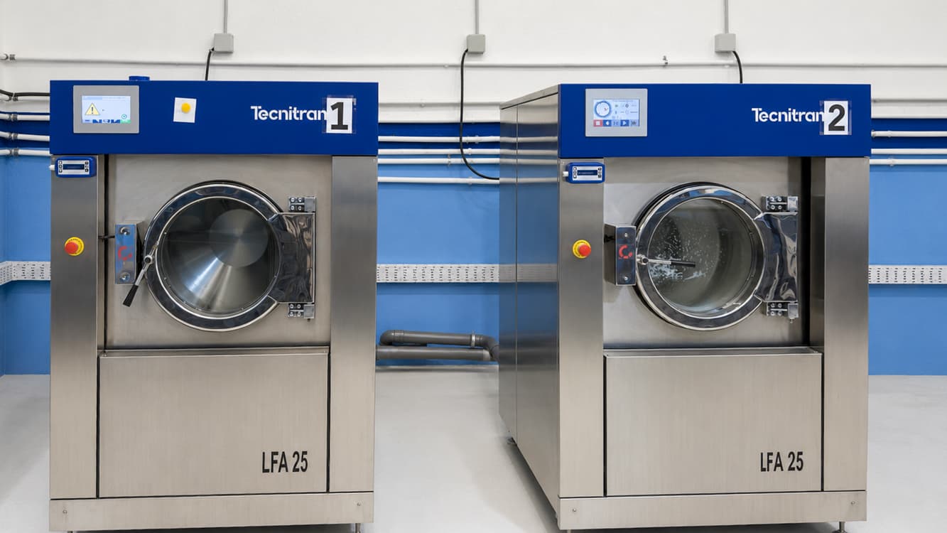 Duas máquinas de lavar industriais Tecnitran na unidade de Loulé, com a parede azul da nave por trás.
